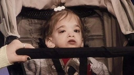 Cô bé không thể di chuyển được và thường xuyên phải ngồi xe đẩy