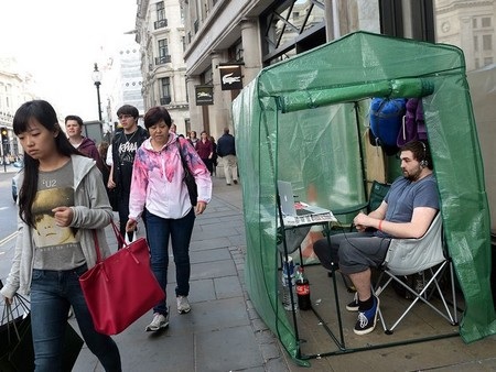 Hàng dài người xếp hàng chờ mua iPhone 6, 6Plus trên khắp thế giới - 11 Một người đang ngồi trong căn lều tại London để chờ đợi thời gian trôi qua.