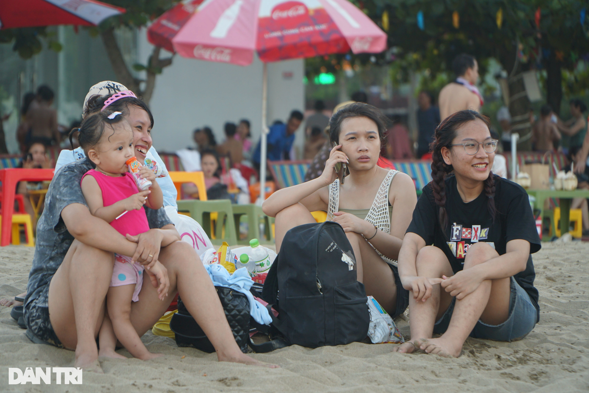 Do lượng du khách xuống tắm quá đông, nhiều người đành ngồi trên bãi cát để hóng gió.