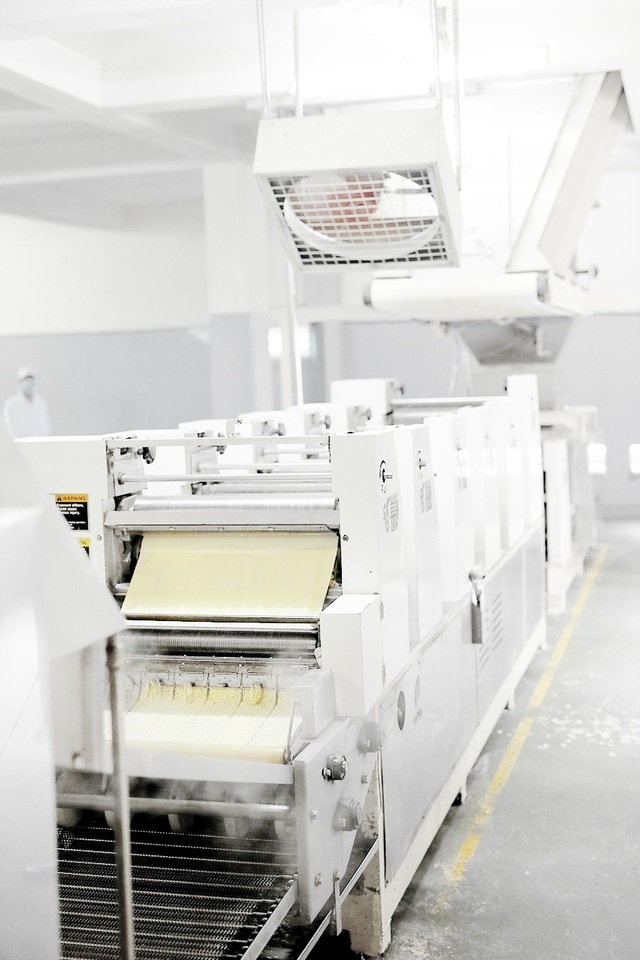 Thâm nhập nhà máy sản xuất mì ăn liền cao cấp hàng đầu tại Việt Nam - 3 Các nguyên liệu được xả xuống cán thô, đùn nhuyễn dưới dạng tấm và cán tinh sau đó đi qua dao cắt sợi. Từ công đoạn này, đã có thể nhận thấy sợi mì làm từ khoai tây có màu vàng sáng khá bắt mắt, mướt và dai.