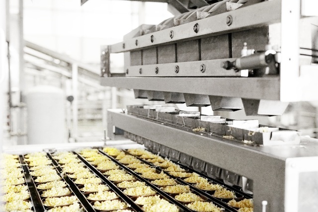 Thâm nhập nhà máy sản xuất mì ăn liền cao cấp hàng đầu tại Việt Nam - 5 Sau khi cắt, mì tiếp tục được chiên bằng dầu để làm bay hơi nước và giảm độ ẩm. Nhiệt độ này luôn được duy trì liên tục suốt quá trình chiên. Dầu chiên được thay theo định kỳ và luôn được giám sát chặt chẽ về thời gian sử dụng và các chỉ số hóa lý.