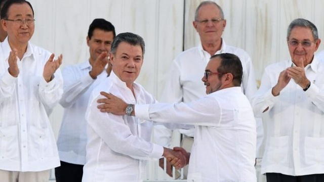 Colombia ký thỏa thuận hòa bình lịch sử, chấm dứt nội chiến kéo dài hơn 50 năm - 1
Tổng thống Colombia Juan Manuel Santos và chỉ huy lực lượng FARC Timoleon Jimenez bắt tay sau lễ ký kết, trước sự chứng kiến của đông đảo các lãnh đạo thế giới (Ảnh: AFP)