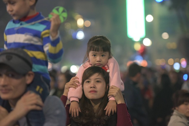 Triệu người cùng đếm ngược hân hoan chào năm 2017 - 28
Một em nhỏ theo mẹ hòa vào dòng người đi đón xuân. (Ảnh: Mạnh Thắng)