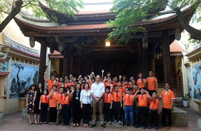 Những hình ảnh đẹp của Hoàng tử William trong chuyến thăm Việt Nam - 11
Hoàng tử William chụp ảnh lưu niệm cùng cô, trò trường Hồng Hà. (Ảnh: Reuters)