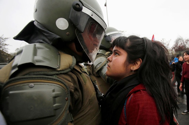 
Một người biểu tình đối đầu với cảnh sát chống bạo động ở Santiago, Chile. (Ảnh: Reuters)
