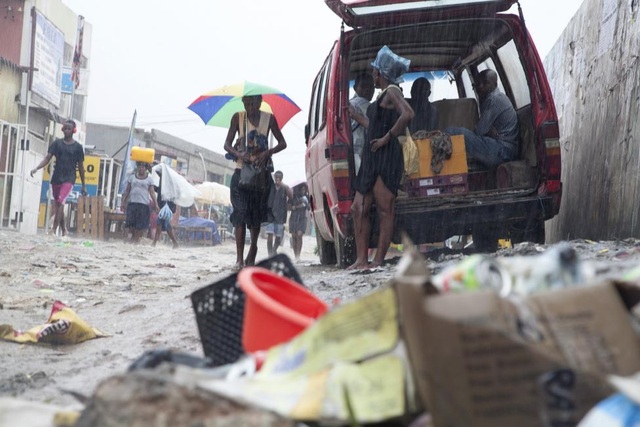 Angola: Người dân chạy băng qua đống rác trên đường trong một cơn mưa ở Luanda, Angola