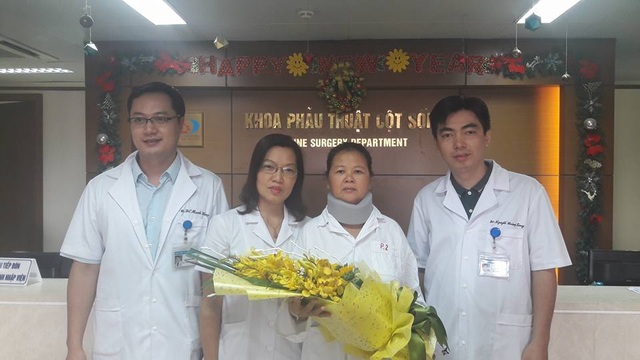 
TS-BS Nguyễn Hoàng Long (ngoài cùng bên phải) cùng các y bác sĩ khoa Phẫu thuật cột sống BV Việt Đức tặng hoa chúc mừng bệnh nhân Dương Thị Miến (thứ 2 từ phải sang) được ra viện và thoát khỏi căn bệnh thoát vị đĩa đệm đốt sống cổ
