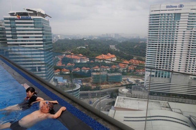 Malaysia: Người dân nghỉ dưỡng ở bể bơi trên tòa nhà cao tầng ở Kuala Lumpur, Malaysia ngày 28/8.
