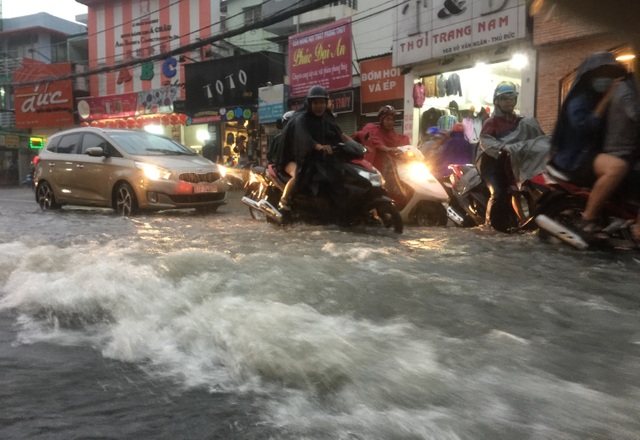 Mưa lớn kết hợp triều cường, nước dâng cuồn cuộn trên đường phố Sài Gòn - 5 Nước mưa như vỡ đê cuồn cuồn đổ xuống dốc trên đường Võ Văn Ngân.