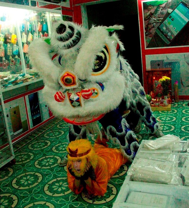 Hàng nghìn người đổ ra đường xem múa lân, đường phố kẹt cứng - 17 Nhiều đội lân vào trong tận cửa hàng múa để kiếm thêm chút tiền thưởng.