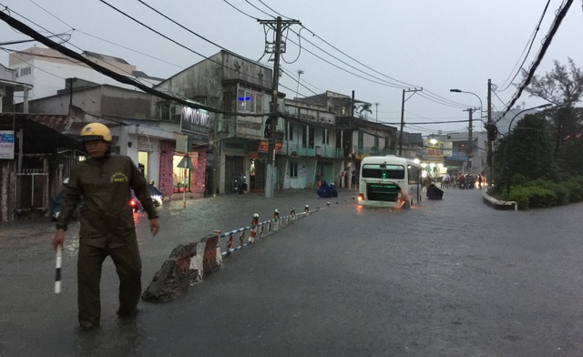 Mưa lớn kết hợp triều cường, nước dâng cuồn cuộn trên đường phố Sài Gòn - 10 CSGT được điều động đến hiện trường điều tiết, hướng dẫn người tham gia giao thông chọn hướng đi khác để tránh vào vùng ngập nước.