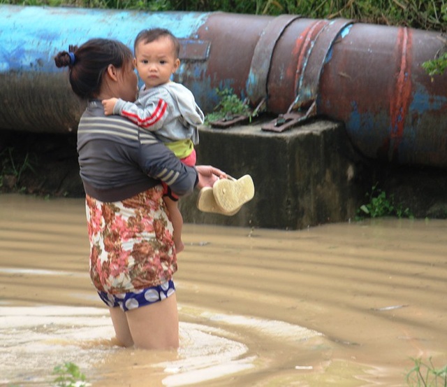 Bão vừa qua, người dân lại gồng mình chống chọi với lũ - 2 Người dân di dời trẻ nhỏ vì sợ lũ có thể dâng cao hơn trong đêm