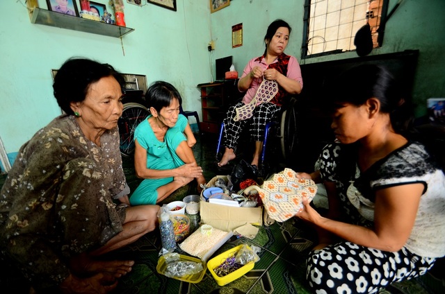 Tấm lòng vàng của nữ vận động viên khuyết tật - 1 Các thành viên trong gia đình chị Thương đang gia công kết cườm.