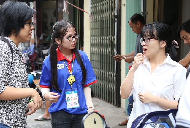 Nữ sinh viên tình nguyện dùng ngôn ngữ đặc biệt hỗ trợ thí sinh khiếm thính - 1 Lê Thị Thuỳ Trang (áo xanh) là sinh viên tình nguyện Tiếp sức mùa thi đã hỗ trợ hai thí sinh khiếm thính tới phòng thi và động viên các bạn bằng ngôn ngữ đặc biệt.