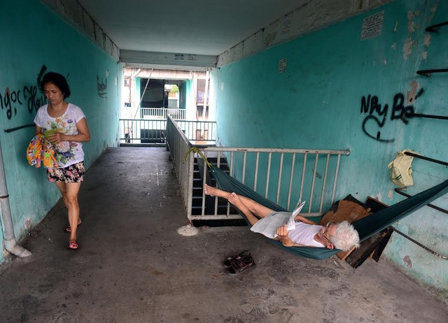 Cuộc sống trong chung cư cũ nát giữa Sài Gòn - 11
Một cụ ông phải mắc võng ngoài hành lang nằm đọc báo vì nhà diện tích nhỏ lại đông người chen chúc.