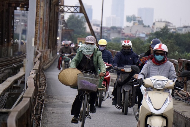 Hà Nội rét đậm, người dân co ro khi ra đường - 11
Một người đi xe đạp liêu xiêu trước cơn gió.