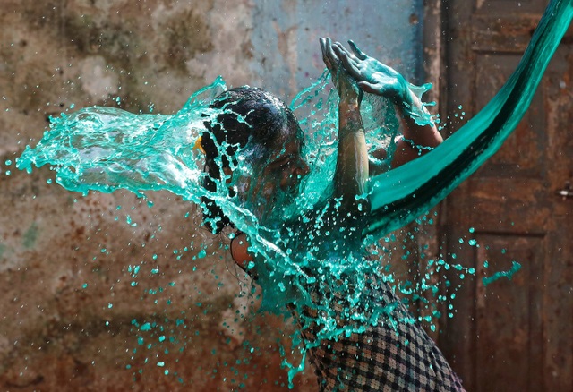 Cô gái thích thú khi bị hắt nước màu trong lễ hội Holi - lễ hội màu sắc - tổ chức ở Mumbai, Ấn Độ. (Ảnh chụp ngày 13/3)