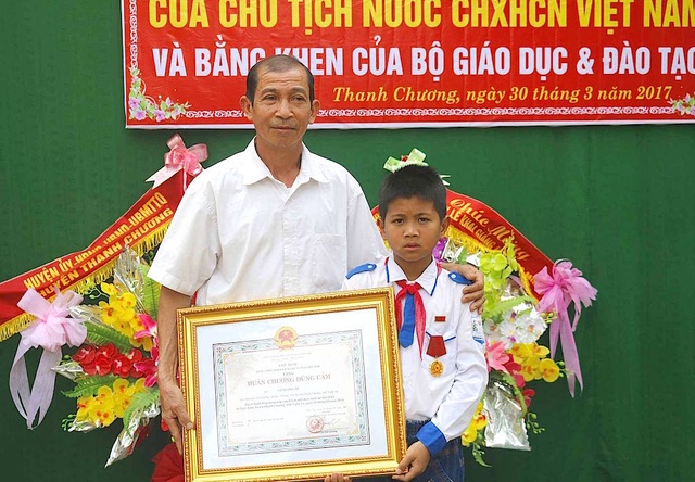 Trao Huân chương của Chủ tịch nước đến học sinh lớp 5 cứu hai em nhỏ khỏi đuối nước - 3 Em Tú và ông nội trong buổi lễ tôn vinh.