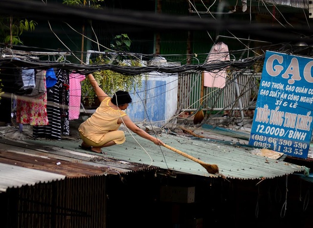 Cuộc sống trong chung cư cũ nát giữa Sài Gòn - 8
Người phụ nữ quét lớp đất bụi do hộ dân phía trên xả xuống.