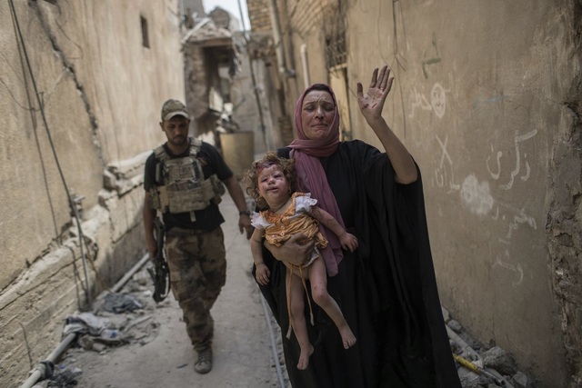 
Vài trăm phiến quân IS còn sót lại vẫn chưa dừng chiến dịch tàn bạo như đánh bom những dân thường, hay lấy trẻ em làm lá chắn sống. Trong ảnh: Người mẹ cố gắng đưa bé gái thương tật đầy mình thoát ra khỏi Mosul. (Ảnh: AP)
