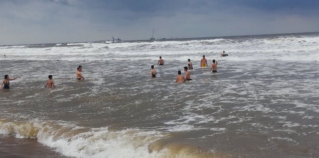 
Người dân vẫn hồn nhiên tắm biển dù sóng lớn.
