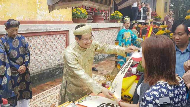 Lễ khai ấn năm mới và hạ nêu trong Hoàng cung Huế - 3 Trao tặng cho du khách các chữ được đóng ấn vua
