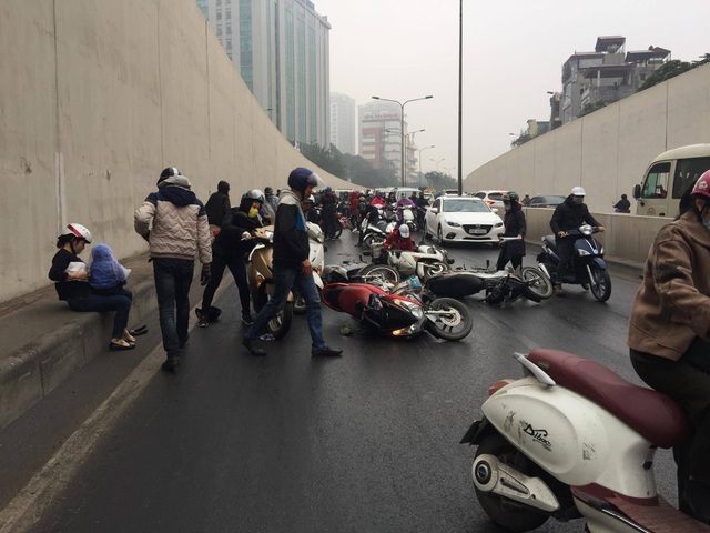 Hàng chục xe máy đổ la liệt trong hầm chui Kim Liên - 9
Một phụ nữ có con nhỏ chân giày chân đất, cuống quýt kiểm tra xem con có bị thương không.