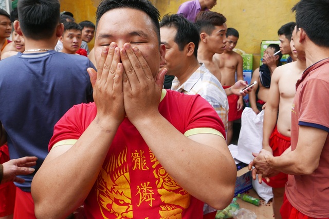 Sức mạnh "đội quân đánh giặc ngoại xâm" ở hội pháo Đồng Kỵ - 5
Trong khi đó, ở khoảng sân sau đình, các trai đinh vuốt nước gừng tẩy uế cơ thể, hoàn tất khâu chuẩn bị cuối cùng trước khi vào trận rước ông đám.