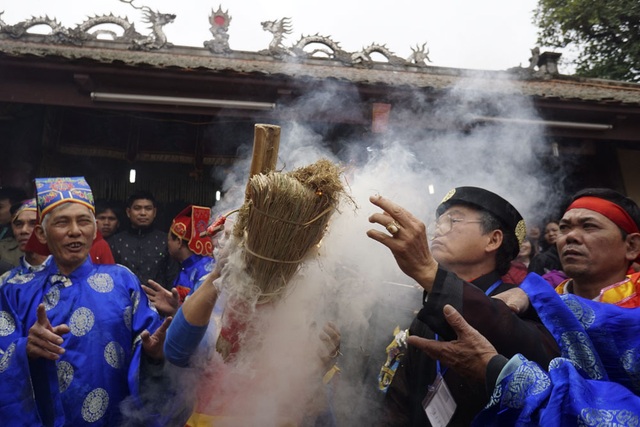 Sôi động trong khói lửa hội thổi cơm thi Thị Cấm - 3 Trong từ 2 - 3 phút ngọn lửa bùng cháy, lúc này người dân giơ cao bùi nhùi và thổi mạnh nuôi lửa chuẩn bị nấu cơm.