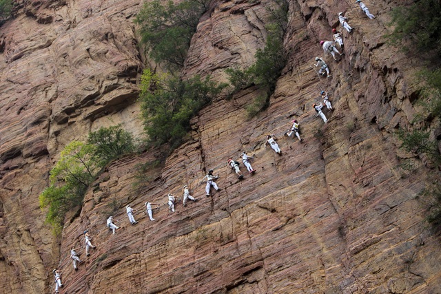 Những người leo núi bám vào một sợi dây thừng chạy dọc một vách đá ở thành phố Lạc Dương, tỉnh Hà Nam, Trung Quốc. (Ảnh chụp ngày 23/9)