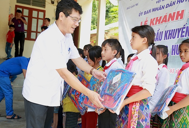 Ngập tràn niềm vui ngày khánh thành cầu Dân trí thứ 13 tại xứ Nghệ - 5 Ông Phạm Trọng Hoàng - Bí thư huyện Ủy Tương Dương trao cặp tới các em học sinh.