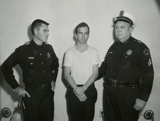 Chủm ảnh hiếm về vụ ám sát Tổng thống Mỹ John F. Kennedy - 20
Ban đầu, Oswald bị cảnh sát bắt không phải do bị tình nghi ám sát tổng thống mà vì tên này đã bắn chết một sĩ quan cảnh sát khi bị yêu cầu dừng lại để kiểm tra chỉ ít lâu sau vụ ám sát diễn ra. Các cuộc điều tra sau này đã kết luận Oswald là hung thủ và hành động một mình, tuy nhiên, điều này dường như vẫn chưa làm hài lòng phần lớn dân chúng và những người ủng hộ các thuyết âm mưu khác
