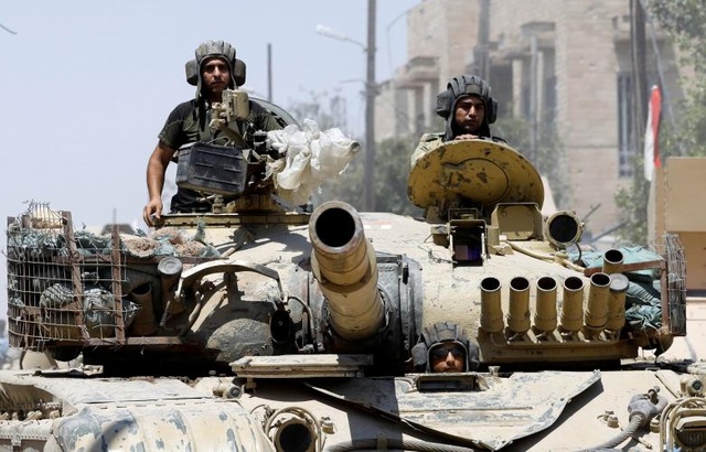 
Các binh sĩ Iraq trên xe tăng tiến về phía thành cổ Mosul (Ảnh: Reuters)
