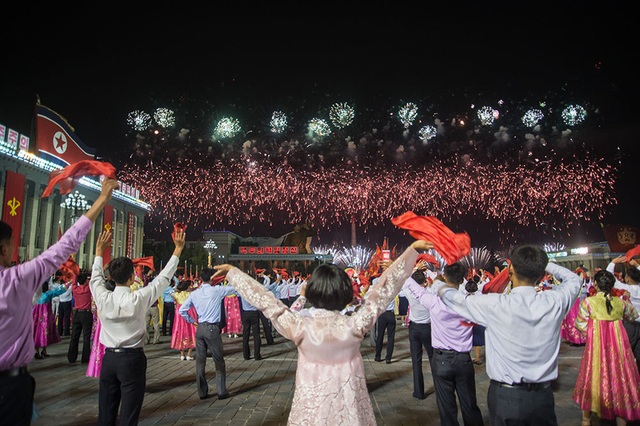 Pháo hoa rợp trời Bình Nhưỡng trong ngày kỉ niệm ông Kim Jong-il lên nắm quyền - 7 Những người tham gia lễ kỉ niệm cùng vẫy tay khi pháo hoa đang được bắn rợp trời trên tháp Juche. (Ảnh: AFP)