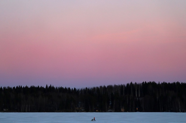 Người phụ nữ đẩy xe nôi qua một mặt hồ nay đã đóng băng, nằm ở thành phố Lahti, Phần Lan. (Ảnh chụp ngày 21/2)