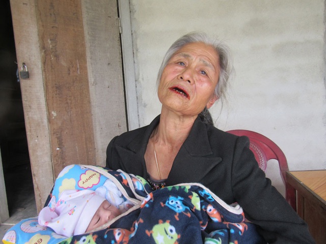 Xót thương cụ bà xin từng ngụm sữa nuôi cháu 2 tuần tuổi của đứa con điên - 3 Bế đứa cháu ngủ ngon trên tay, bà Hoài không ngừng rơi nước mắt kể về cuộc đời bất hạnh.