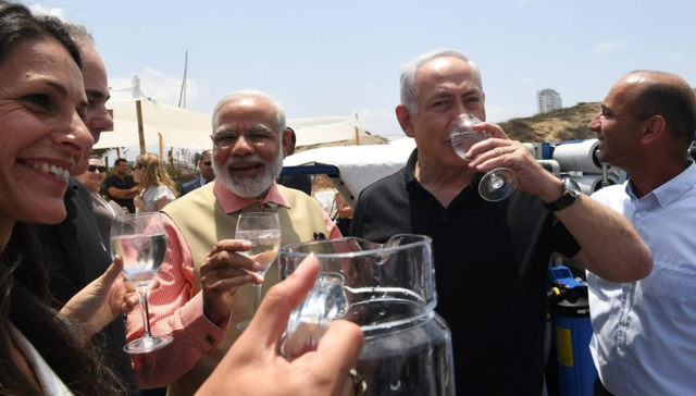 Thủ tướng Ấn Độ xắn quần dạo biển cùng lãnh đạo Israel - 3 Hai nhà lãnh đạo uống nước tinh khiết lọc từ nước biển ngay tại bờ biển của Israel (Ảnh: Twitter)