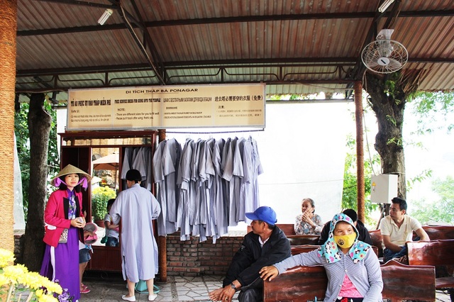 Nha Trang: Du khách mặc hở hang được cho mượn áo dài khi hành hương - 5 Một nữ du khách tự thấy mặc chưa phù hợp nên đã xin mặc áo dài lam