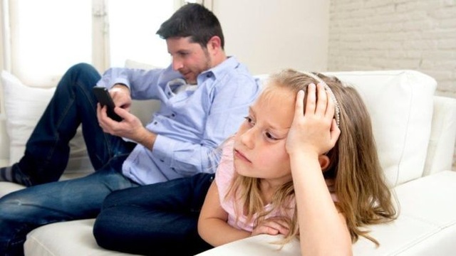Cha mẹ lạm dụng điện thoại “bỏ rơi” con cái - 1 Cha mẹ liên tục sử dụng điện thoại di động có thể khiến trẻ em cảm thấy buồn bã và bị bỏ rơi. (Ảnh: theo BBC)