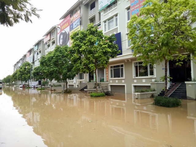 
Mưa lớn cũng khiến cho các dãy biệt thự khu đường Lê Trọng Tấn,An Khánh bị ngập sâu. Toàn bộ các hầm để xe chìm trong biển nước, nhiều gia đình phải lấy bao cát chắn trước cửa đề phòng nước tràn vào hầm
