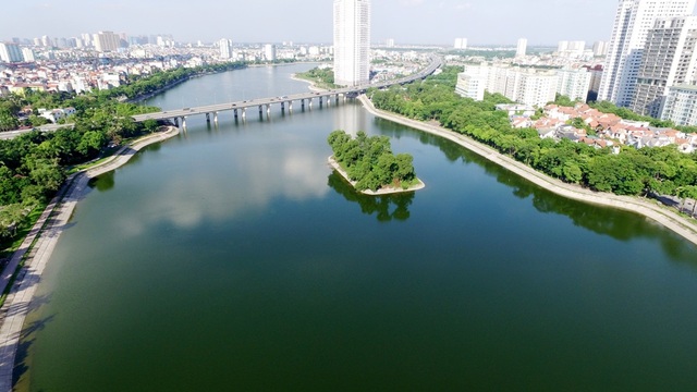 Đẹp ngỡ ngàng hồ Hà Nội nhìn từ trên cao - 2 Hiện nay xung quanh khu vực Hồ Linh Đàm được xây dựng khá nhiều khu đô thị, các tòa nhà cao tầng… ít nhiều cũng làm thay đổi cảnh quan, môi trường ở khu vực này. Hồ Linh Đàm từng nhiều lần bị ô nhiễm, bủa vây bởi rác thải sinh hoạt. Sau sự cố cá chết cách đây 1 năm, nhà chức trách đã tiến hành dọn dẹp, vệ sinh mặt nước. Nhìn từ trên cao, hồ Linh Đàm uốn lượn mềm mại tạo nên điểm nhấn đẹp mắt cho Thủ đô.
