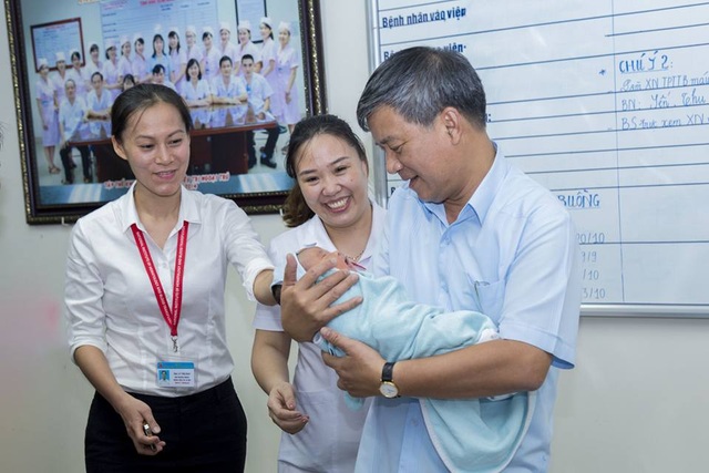 Nhờ người bế con, bà mẹ trẻ bỏ lại bé trai kháu khỉnh 5 ngày tuổi tại bệnh viện - 1 Cậu bé bụ bẫm, kháu khỉnh được các nhân viên của bệnh viện thay nhau chăm sóc, bế bồng. GS Trí (người đang bế bé) mong rằng mẹ cháu bé sau phút bồng bột sẽ quay lại bệnh viện nhận con. Ảnh: BS cung cấp.