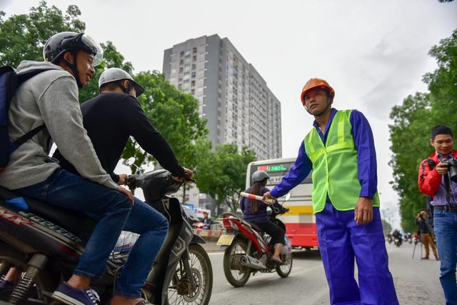 Hà Nội bắt đầu chặt hạ gần 1.300 cây xanh trên đường Phạm Văn Đồng - 10
Tại các điểm xử lý cây, đơn vị thi công bố trí người hướng dẫn giao thông để đảm bảo an toàn.