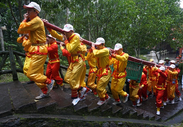 Đội mưa gánh cặp bánh chưng 700kg lên núi dâng thân mẫu Bác Hồ - 2 20 thanh niên trai tráng gánh bánh chưng lên những bậc thang đá dốc đứng.