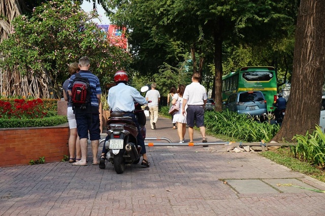 Xe máy uốn lượn vượt "chướng ngại vật" trên vỉa hè - 4
Người đàn ông đi xe máy chen lấn với người đi bộ, tìm cách lách qua barie trong sự ngỡ ngàng của du khách nước ngoài.