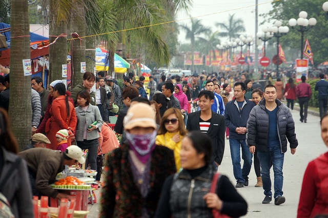 Dòng người tấp nập đổ về đền Trần trước giờ khai ấn - 6
Nhiều du khách vừa đi vừa nán lại xem đồ lưu niệm