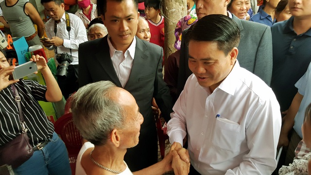 Dọc đường, Chủ tịch Nguyễn Đức Chung bắt tay thăm hỏi, động viên người dân Đồng Tâm.