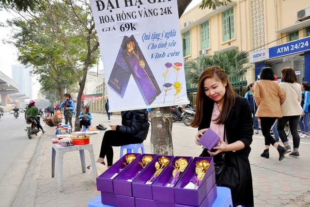 Hoa hồng dát vàng giá 60 nghìn đồng bán nhiều trên vỉa hè Hà Nội - 1
Dù đã giảm nhiệt và không còn là mặt hàng “hot” được săn lùng như những năm trước, hoa hồng mạ vàng vẫn được nhiều người lựa chọn làm quà tặng trong dịp lễ tình nhân năm nay. Tại nhiều tuyến phố ở Hà Nội, hoa hồng mạ vàng 24k được bày bán ngay trên vỉa hè với giá bán giao động từ 60 nghìn – 150 nghìn đồng/bông.