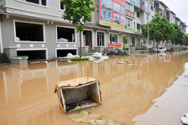 Nhiều khu đô thị chìm trong biển nước sau cơn mưa lớn ở Hà Nội - 9 Nước ngập cuốn trôi rác thải vào hầm nhà dân, nhiều hộ gia đình phải liên tục vớt rác để tránh hiện tượng ùn ứ