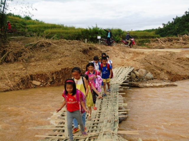 Xã biên giới tan hoang sau trận lũ lịch sử - 12 Đường trở lại trường học của nhiều học sinh khó khăn hơn sau cơn lũ. Người dân phải bắc cầu tạm bợ cho các cháu đến trường.